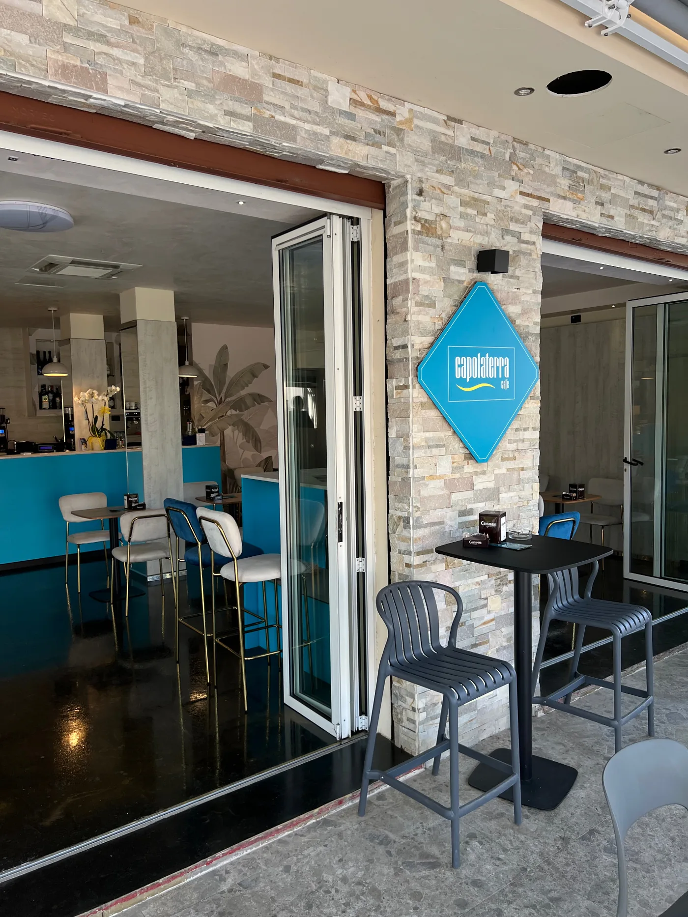 Insegna a diamante Capolaterra Cafè all'ingresso del locale