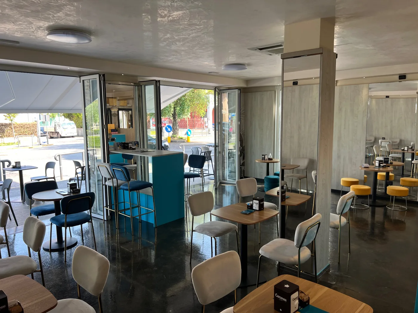 Sala interna luminosa di Capolaterra Cafè con vetrate apribili