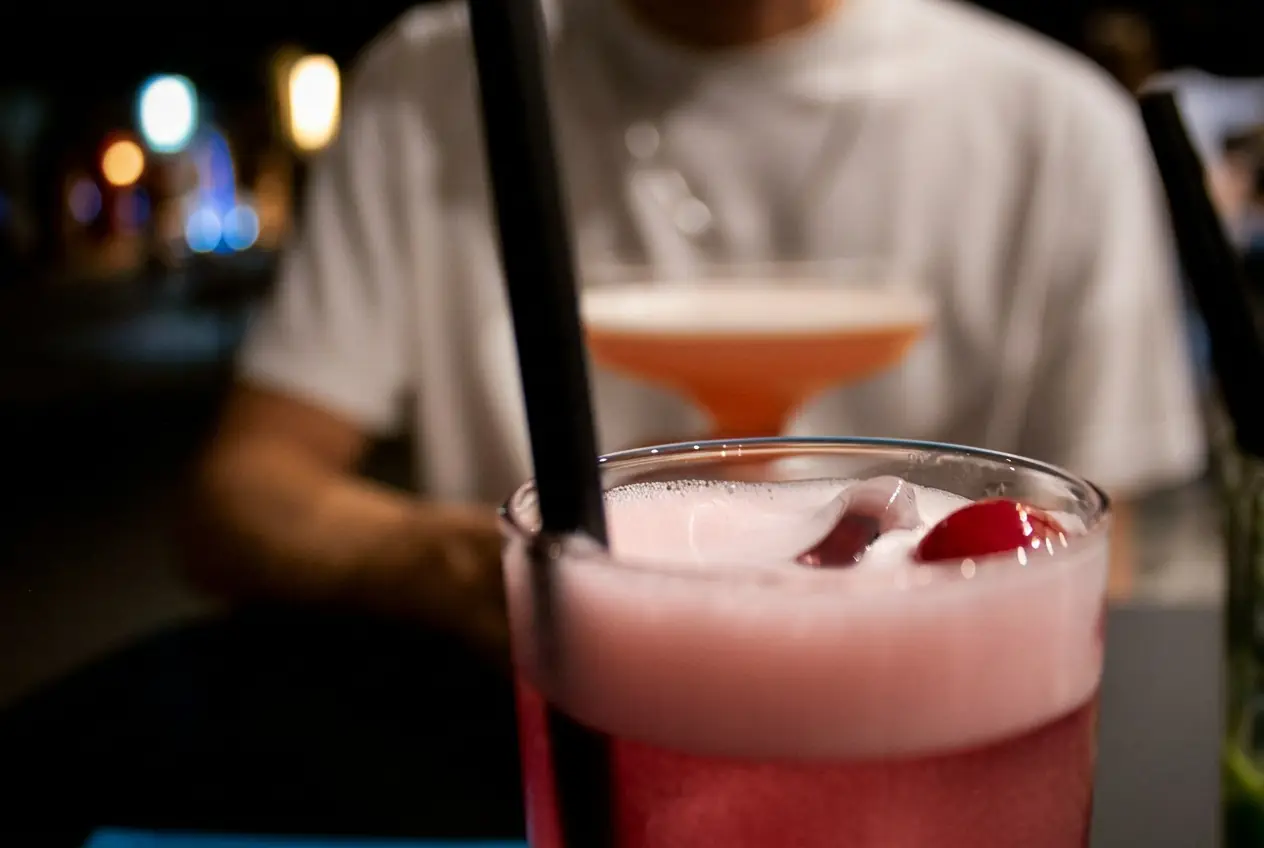 Drink rosa con schiuma e ciliegie in primo piano da Capolaterra Cafè